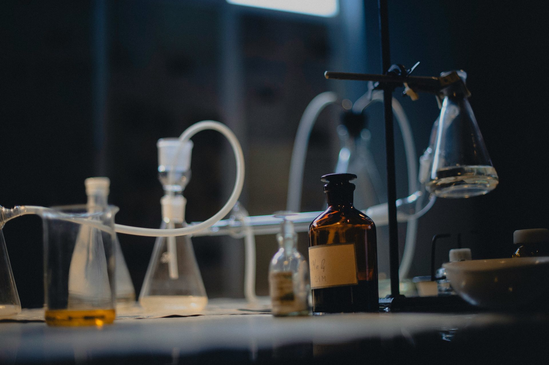 Laboratory glassware sits on a dark, illuminated table.